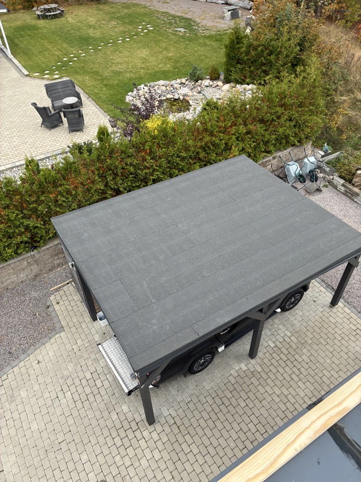 Papptak på garage och carport i bostadsmiljö sett ovanifrån.